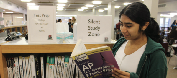 Persistent preparation: Junior Jessica Joseph looks over an Advanced Placement U.S. Government and Politics book in the library to study for her AP test. In July, the College Board announced that 28 out of the total 39 AP exams are transitioning to digital or hybrid formats in May 2025.